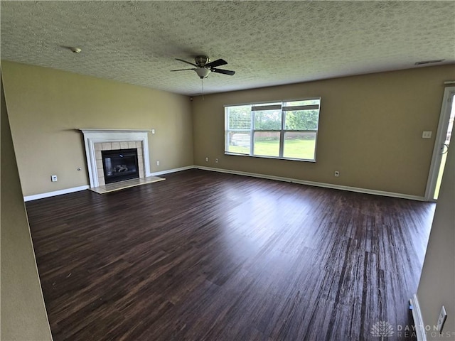 8736 Gingerwood Ct, Franklin, OH 45005 - unfurnished living room featuring wood finished floors, a ceiling fan, a tile fireplace, and a textured ceiling
