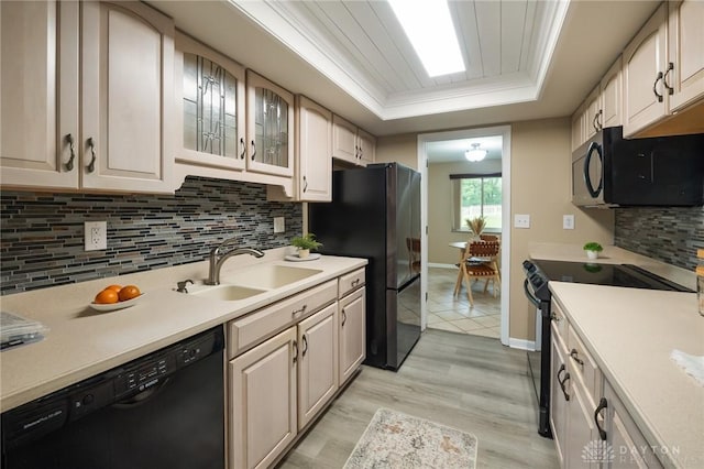 521 Park Ridge Dr, Centerville, OH 45459 - kitchen featuring black appliances, a tray ceiling, light wood-style flooring, light countertops, and tasteful backsplash