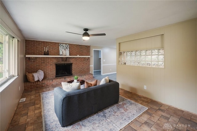 521 Park Ridge Dr, Centerville, OH 45459 - living room with ceiling fan, stone finish flooring, a fireplace, and wood walls