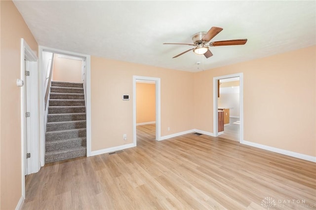 824 Euclid St, Bellefontaine, OH 43311 - unfurnished room featuring ceiling fan, light wood-style flooring, and stairway