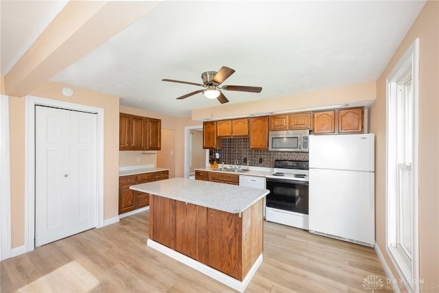 824 Euclid St, Bellefontaine, OH 43311 - kitchen featuring white appliances, brown cabinetry, light wood-style floors, and tasteful backsplash