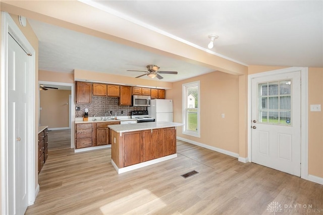 824 Euclid St, Bellefontaine, OH 43311 - kitchen with stainless steel microwave, electric range, freestanding refrigerator, brown cabinets, and a ceiling fan