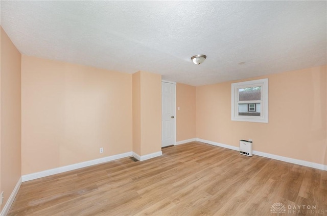824 Euclid St, Bellefontaine, OH 43311 - spare room featuring light wood-style flooring and a textured ceiling