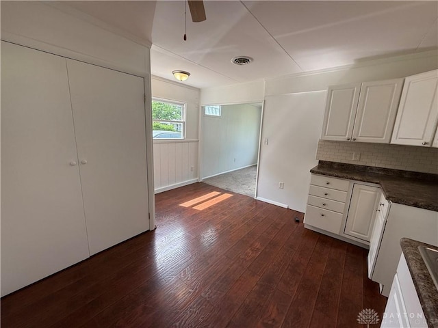 874 Bristol Dr, Vandalia, OH 45377 - kitchen featuring dark countertops, dark wood-style flooring, white cabinetry, decorative backsplash, and ceiling fan