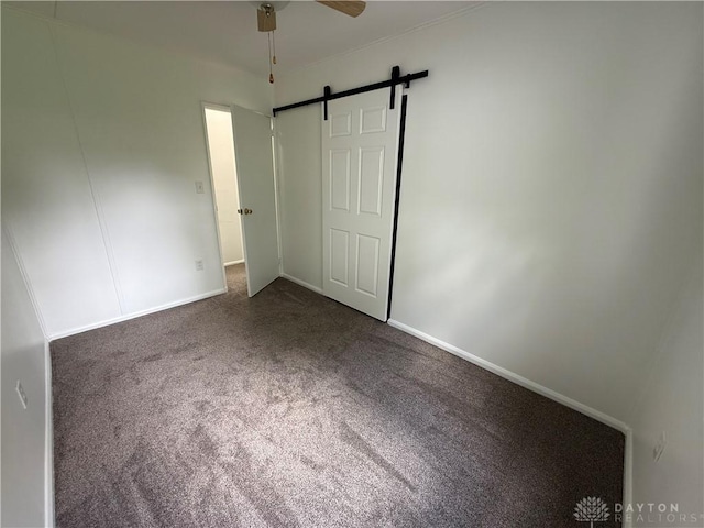 874 Bristol Dr, Vandalia, OH 45377 - unfurnished bedroom with carpet flooring, a barn door, and ceiling fan