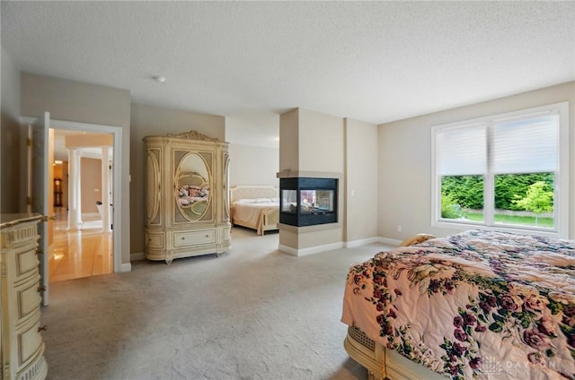 655 Devanshae Ct, Hamilton, OH 45013 - bedroom featuring light carpet, a textured ceiling, and a multi sided fireplace