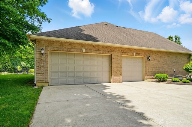 655 Devanshae Ct, Hamilton, OH 45013 - view of side of home with brick siding, a shingled roof, driveway, and a garage