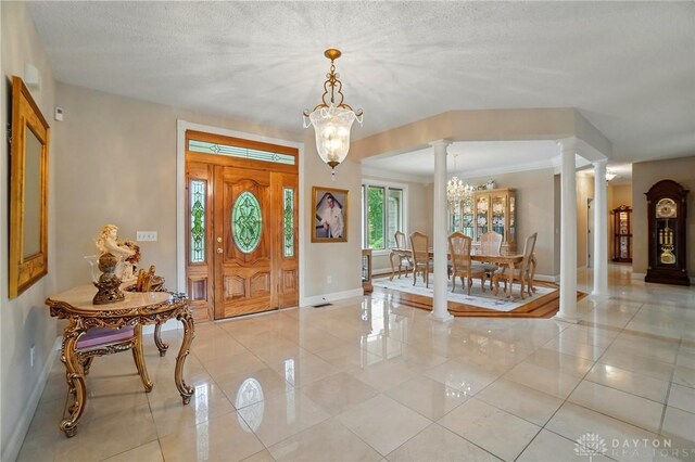 655 Devanshae Ct, Hamilton, OH 45013 - foyer featuring decorative columns, a chandelier, and light tile patterned flooring