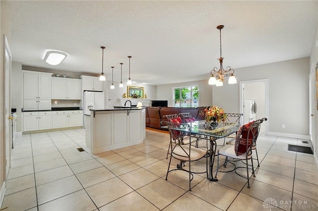 655 Devanshae Ct, Hamilton, OH 45013 - kitchen with dark countertops, open floor plan, light tile patterned floors, white cabinetry, and white refrigerator with ice dispenser