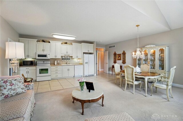 655 Devanshae Ct, Hamilton, OH 45013 - living room featuring light colored carpet, light tile patterned flooring, and a chandelier
