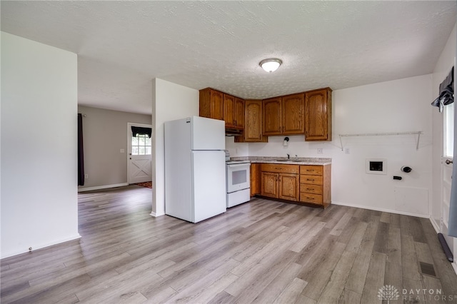 1919 Atkinson Dr, Xenia, OH 45385 - kitchen with white appliances, brown cabinets, light wood-type flooring, light countertops, and under cabinet range hood