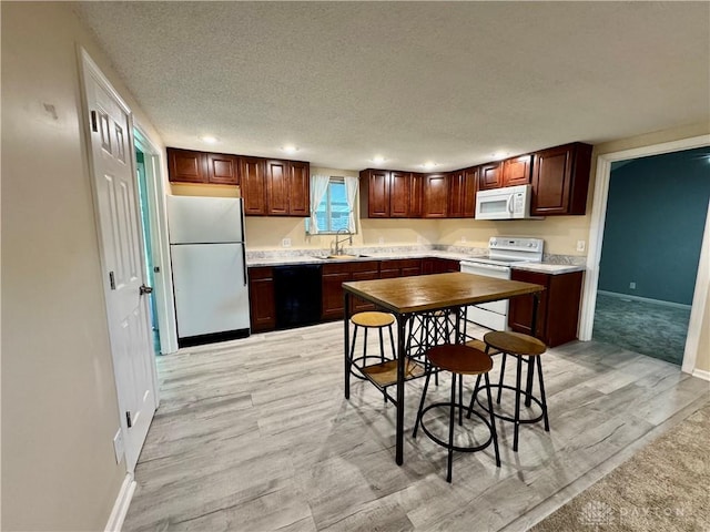 3626 Merwin 10 Mile Rd, Oh, OH 45245 - kitchen featuring white appliances, light wood-type flooring, recessed lighting, a textured ceiling, and light countertops