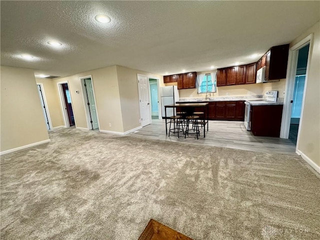 3626 Merwin 10 Mile Rd, Oh, OH 45245 - kitchen featuring white appliances, light carpet, a textured ceiling, light countertops, and open floor plan