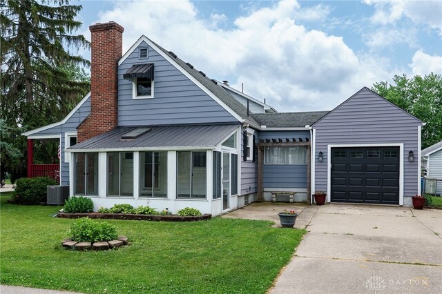 1603 Rosemont Blvd, Dayton, OH 45410 - view of front facade with a sunroom, a chimney, concrete driveway, an attached garage, and a front lawn