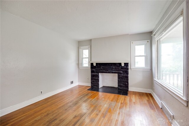 1603 Rosemont Blvd, Dayton, OH 45410 - unfurnished living room with light wood-type flooring and a fireplace with flush hearth