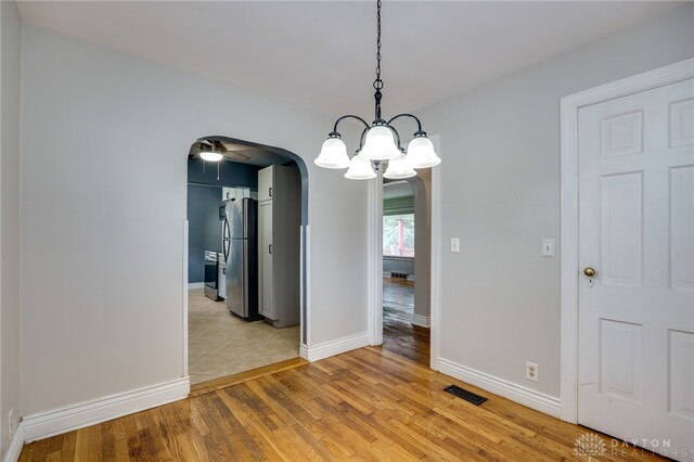 1603 Rosemont Blvd, Dayton, OH 45410 - unfurnished dining area featuring arched walkways, light wood finished floors, a chandelier, and ceiling fan