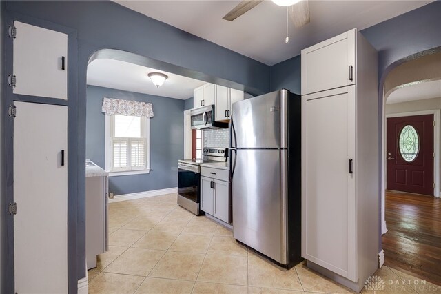 1603 Rosemont Blvd, Dayton, OH 45410 - kitchen with stainless steel appliances, arched walkways, a ceiling fan, light tile patterned floors, and white cabinets