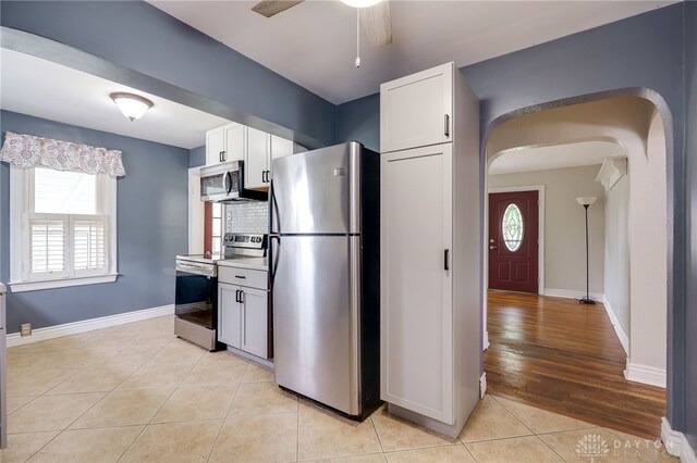 1603 Rosemont Blvd, Dayton, OH 45410 - kitchen featuring stainless steel appliances, arched walkways, light tile patterned floors, and plenty of natural light