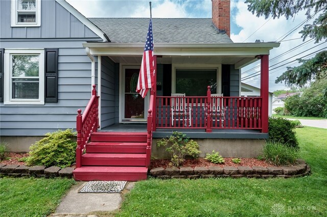 1603 Rosemont Blvd, Dayton, OH 45410 - bungalow-style house with covered porch, a chimney, a shingled roof, a front lawn, and board and batten siding