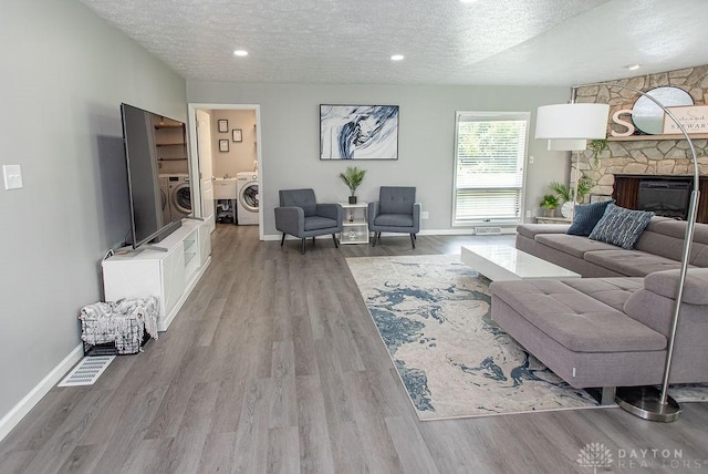 881 Garver Rd, Monroe, OH 45044 - living area with a textured ceiling, washer / dryer, wood finished floors, and a fireplace
