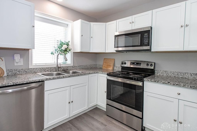 881 Garver Rd, Monroe, OH 45044 - kitchen featuring stainless steel appliances, light wood finished floors, white cabinetry, and light stone countertops