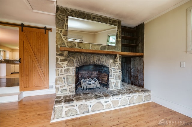 3201 Sears Rd, Spring Valley Twp, OH 45370 - detailed view of wood finished floors, ornamental molding, a barn door, and a stone fireplace