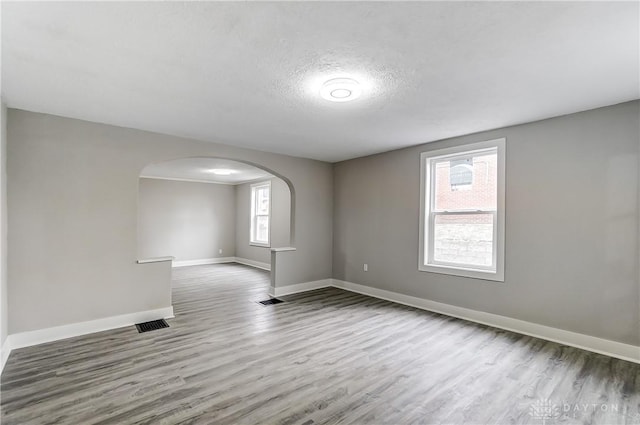 1601 Rausch Ave, Dayton, OH 45432 - spare room with arched walkways, wood finished floors, and a textured ceiling