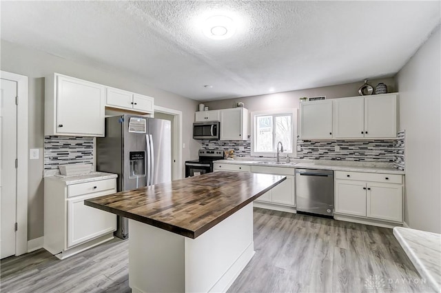 1601 Rausch Ave, Dayton, OH 45432 - kitchen featuring stainless steel appliances, butcher block counters, white cabinetry, light wood-style floors, and decorative backsplash