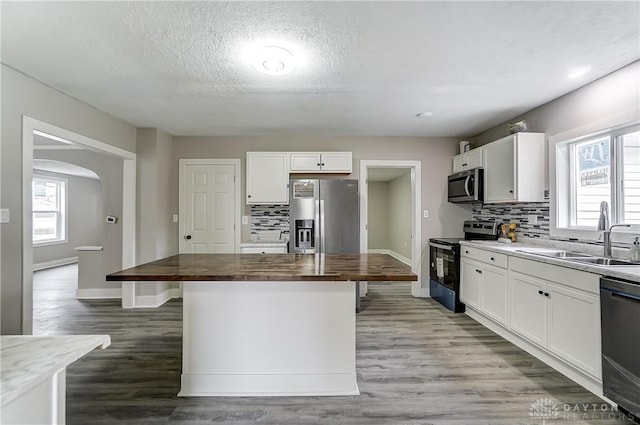 1601 Rausch Ave, Dayton, OH 45432 - kitchen featuring appliances with stainless steel finishes, butcher block counters, a center island, backsplash, and a textured ceiling