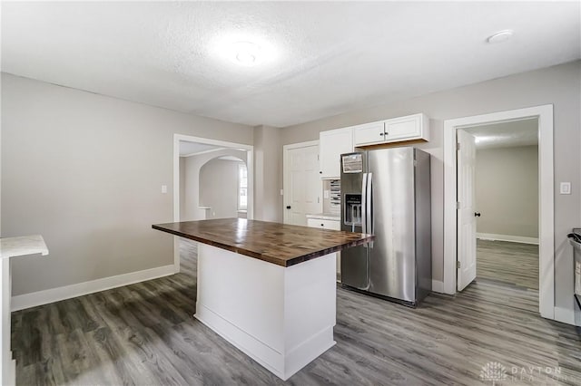 1601 Rausch Ave, Dayton, OH 45432 - kitchen with stainless steel refrigerator with ice dispenser, butcher block counters, arched walkways, wood finished floors, and a textured ceiling