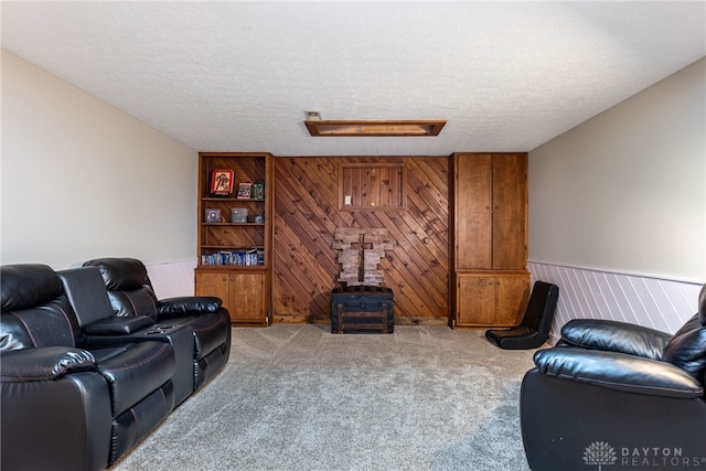 195 Sycamore Creek Dr, Springboro, OH 45066 - carpeted living area with a textured ceiling, wooden walls, attic access, and a wainscoted wall
