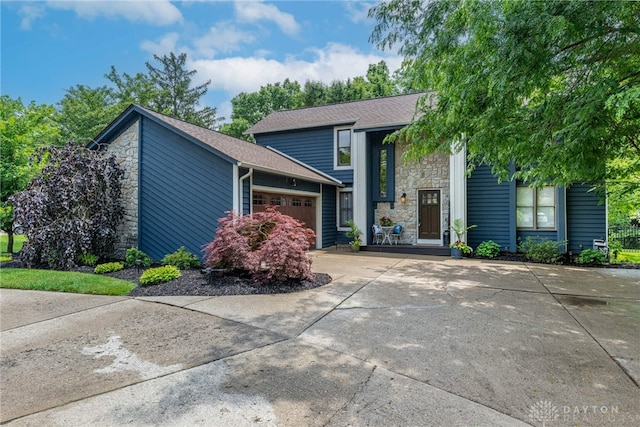 195 Sycamore Creek Dr, Springboro, OH 45066 - view of front of house with stone siding, an attached garage, concrete driveway, and roof with shingles