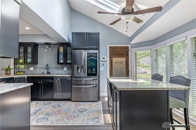 195 Sycamore Creek Dr, Springboro, OH 45066 - kitchen with stainless steel appliances, light stone countertops, tasteful backsplash, glass insert cabinets, and ceiling fan