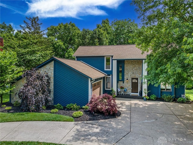 195 Sycamore Creek Dr, Springboro, OH 45066 - view of front of home with stone siding, an attached garage, concrete driveway, and roof with shingles