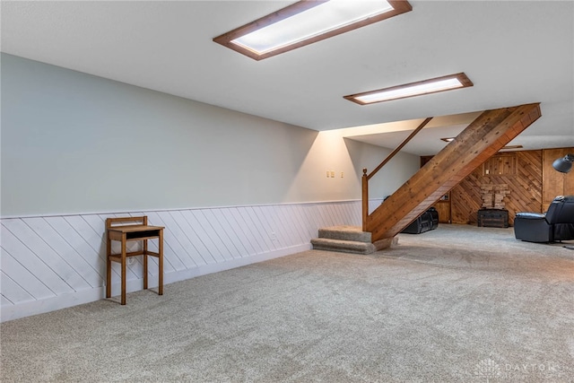 195 Sycamore Creek Dr, Springboro, OH 45066 - below grade area featuring a wood stove, carpet floors, wood walls, wainscoting, and stairs