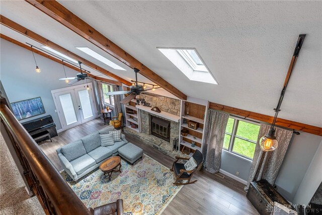 195 Sycamore Creek Dr, Springboro, OH 45066 - living room featuring a skylight, a ceiling fan, wood finished floors, a fireplace, and a textured ceiling