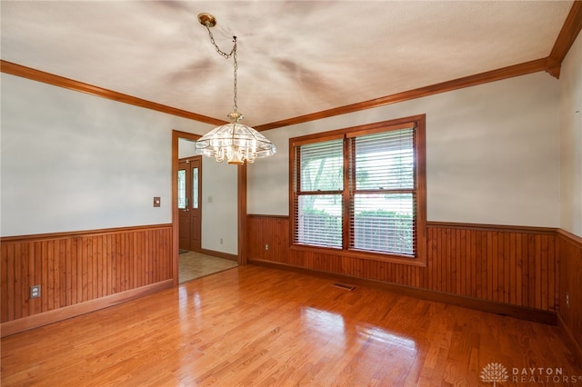 4911 Arabian Dr, Fairborn, OH 45324 - unfurnished room with a wainscoted wall, a chandelier, light wood finished floors, ornamental molding, and wood walls
