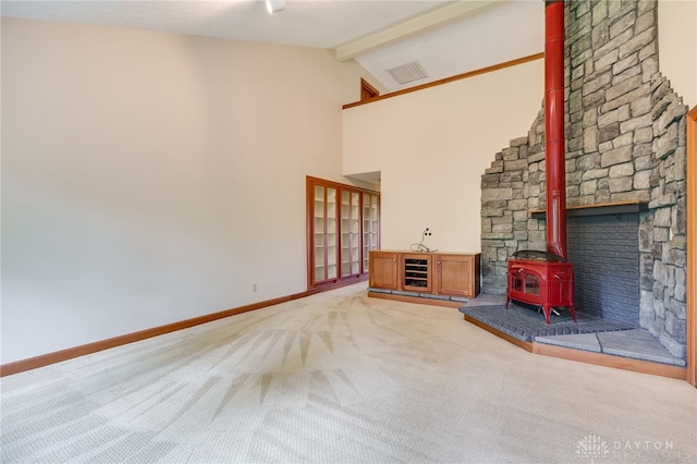 4911 Arabian Dr, Fairborn, OH 45324 - unfurnished living room featuring a wood stove, light carpet, beamed ceiling, and high vaulted ceiling