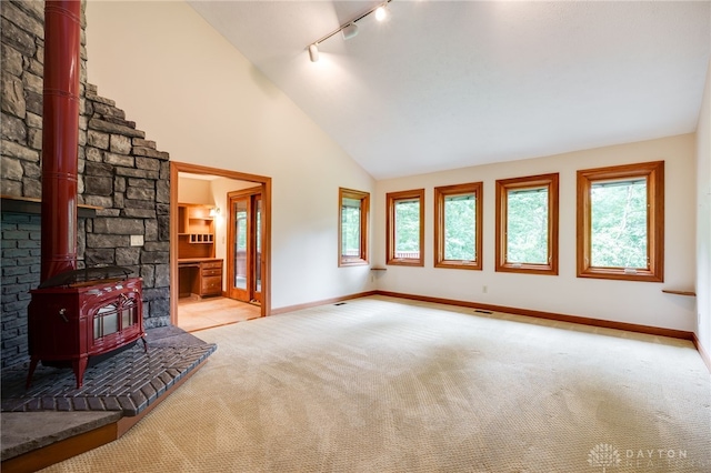 4911 Arabian Dr, Fairborn, OH 45324 - unfurnished living room with track lighting, a wood stove, carpet flooring, and high vaulted ceiling