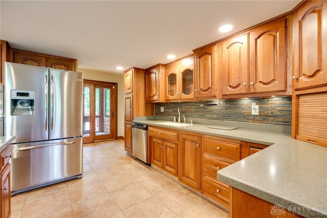 4911 Arabian Dr, Fairborn, OH 45324 - kitchen with appliances with stainless steel finishes, decorative backsplash, light tile patterned flooring, brown cabinetry, and recessed lighting