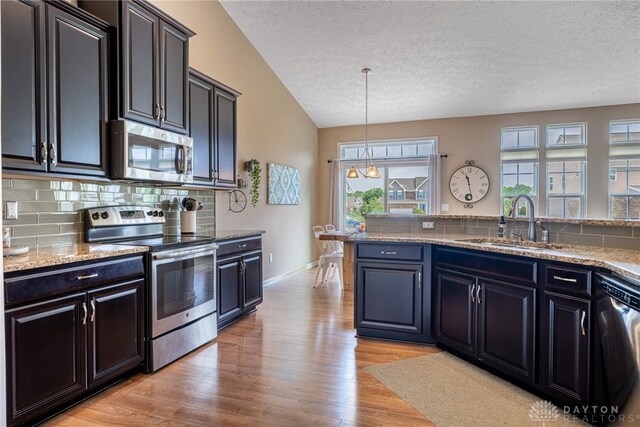 8695 Dijon Ct, Washington Twp, OH 45458 - kitchen with stainless steel appliances, backsplash, a textured ceiling, light wood-style floors, and vaulted ceiling