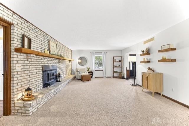 116 Whisman Dr, Middletown, OH 45042 - living room featuring a wood stove and light colored carpet