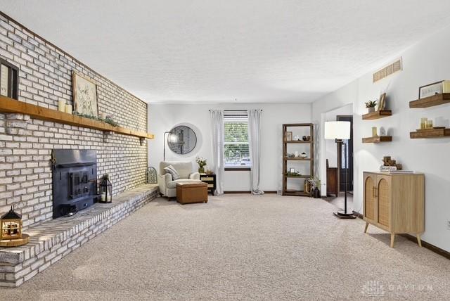116 Whisman Dr, Middletown, OH 45042 - carpeted living area with a wood stove and a textured ceiling
