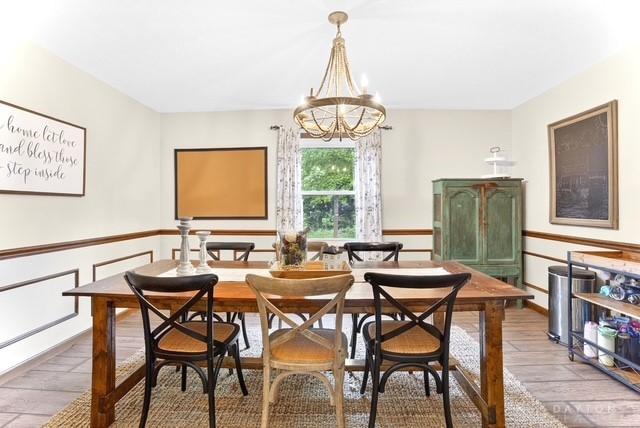 116 Whisman Dr, Middletown, OH 45042 - dining space featuring a chandelier, wood finished floors, and a wainscoted wall