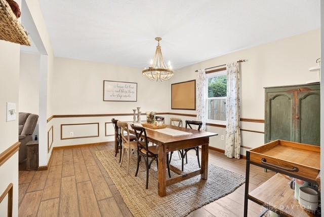 116 Whisman Dr, Middletown, OH 45042 - dining room featuring light wood-style floors, a chandelier, and a wainscoted wall