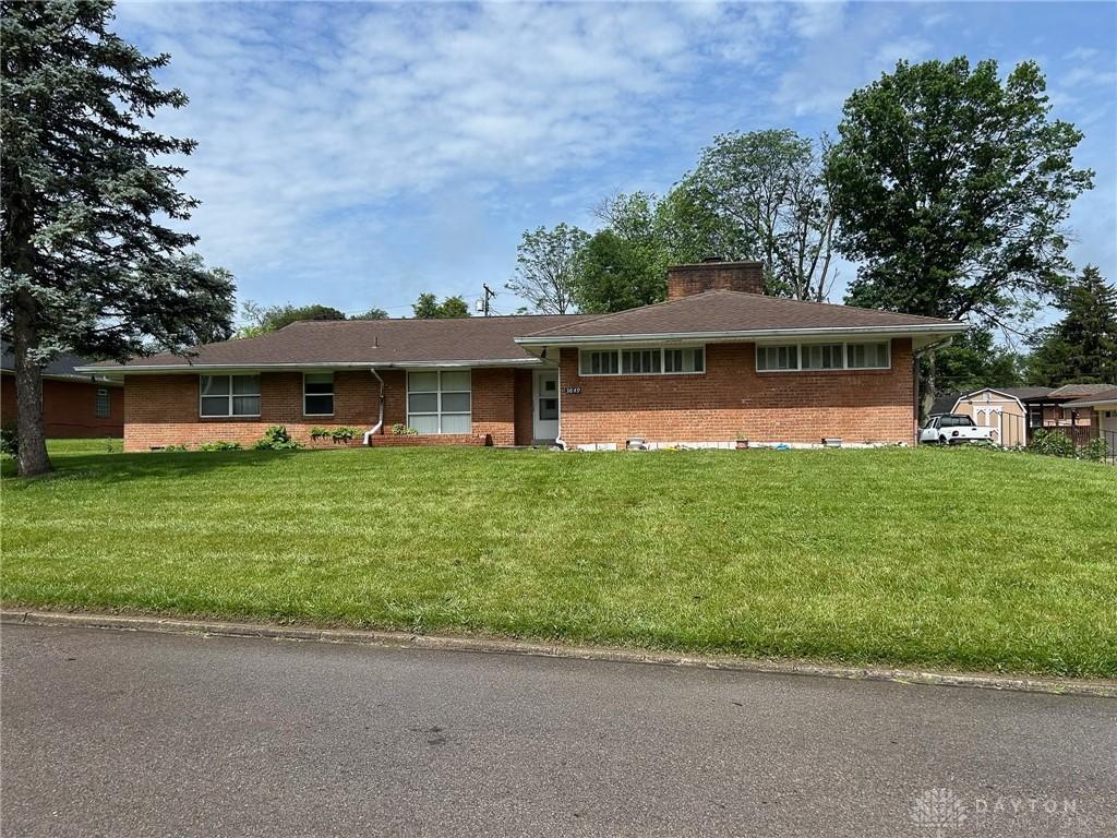 3849 Seiber Ave, Dayton, OH 45405 - view of front of property featuring brick siding, a front yard, and a chimney