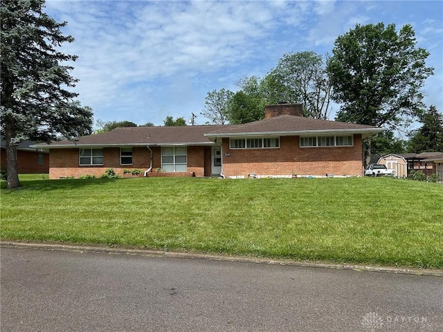 3849 Seiber Ave, Dayton, OH 45405 - view of front of property featuring brick siding, a front yard, and a chimney