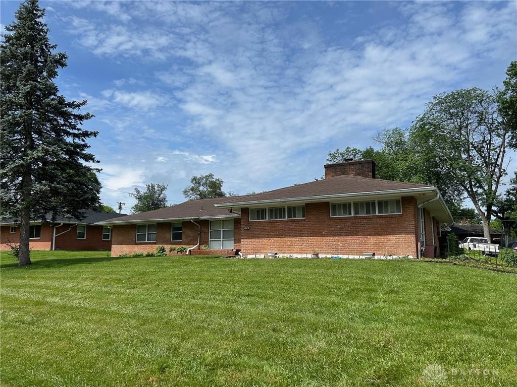 3849 Seiber Ave, Dayton, OH 45405 - ranch-style home with brick siding, a front lawn, and a chimney