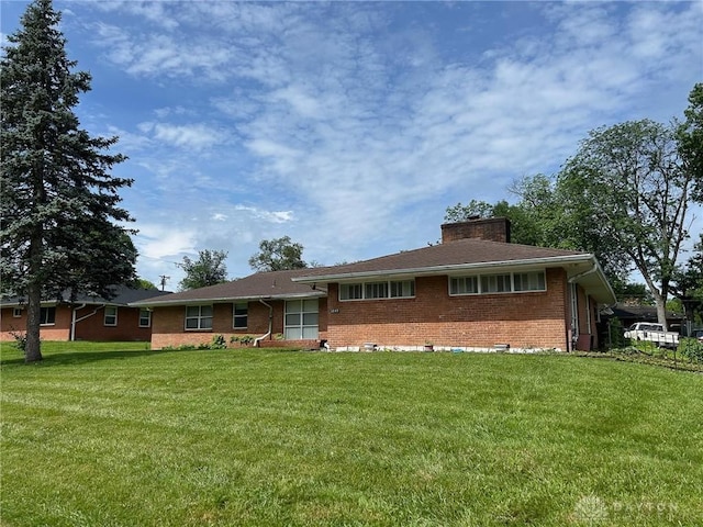 3849 Seiber Ave, Dayton, OH 45405 - ranch-style home with brick siding, a front lawn, and a chimney
