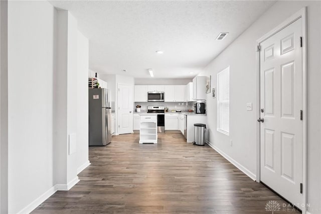 805 Marshall Dr, Xenia, OH 45385 - kitchen featuring appliances with stainless steel finishes, dark wood finished floors, white cabinets, light countertops, and a center island